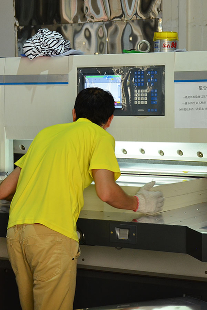 MC Packaging employee operating machinery to produce custom packaging boxes
