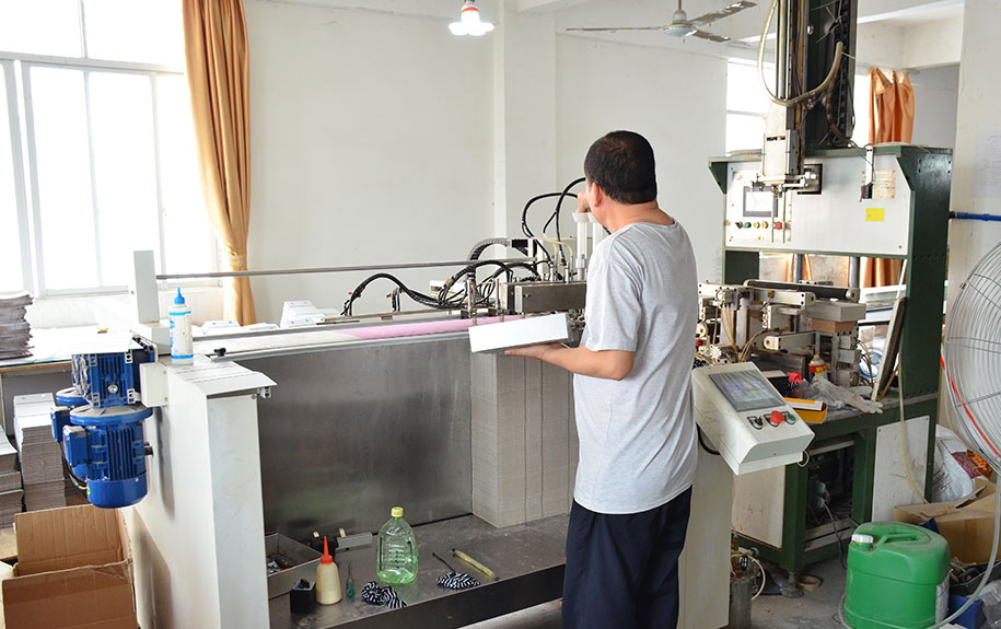 MC Packaging employee using advanced machinery to create custom packaging solutions